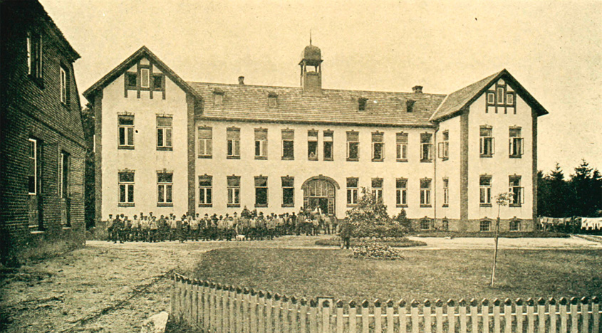 Das neue Wohnhaus der Heimatkolonie Schäferhof im Jahr 1904 mit vielen Arbeitern, die davor stehen.